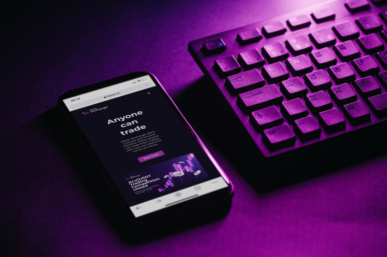 home-img Close-up of a smartphone and keyboard with a purple hue, embodying modern technology and connectivity.